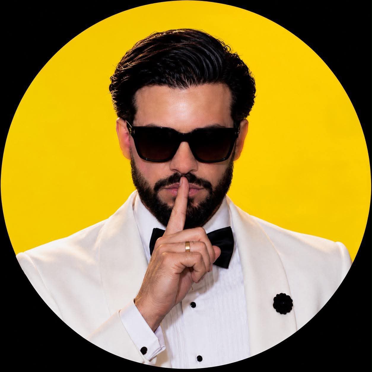 Papi Zero con el dedo en los labios sobre fondo amarillo